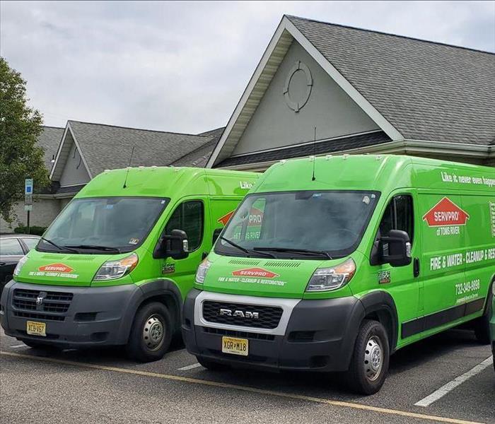 two green SERVPRO vans in a parking lot